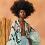 A picture of a Caribbean woman wearing a floral pant suit.