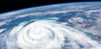 An illustration of a large, swirling hurricane forming over the ocean as it would appear from space.