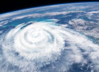An illustration of a large, swirling hurricane forming over the ocean as it would appear from space.
