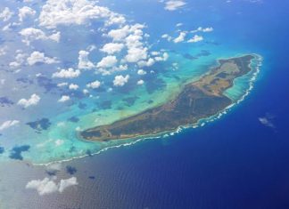 An aerial view of Anegada, a Caribbean island in the British Virgin Islands. White clouds hover above the island.