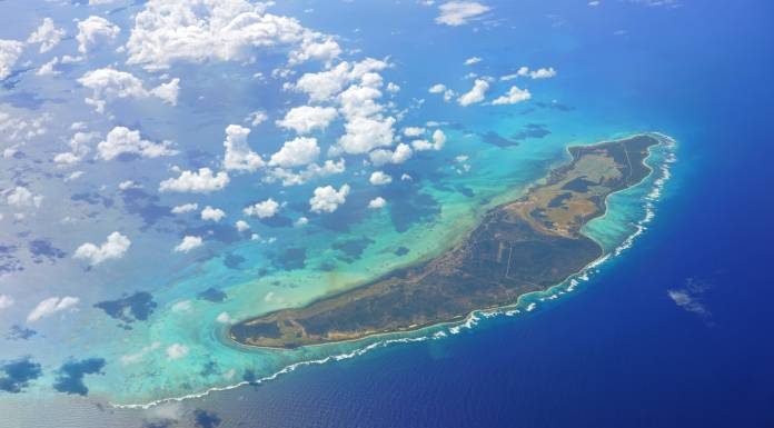 An aerial view of Anegada, a Caribbean island in the British Virgin Islands. White clouds hover above the island.