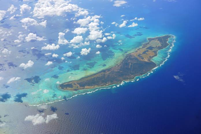 An aerial view of Anegada, a Caribbean island in the British Virgin Islands. White clouds hover above the island.