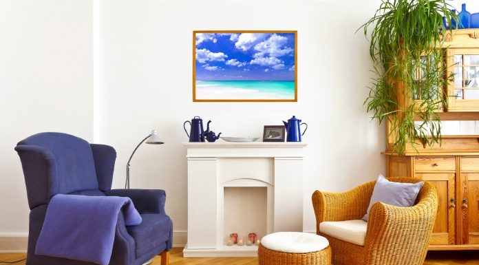 A living room with fireplace mantel featuring blue decorations, blue wingback chair, and wicker chair with matching ottoman.