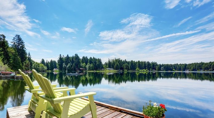 4 Spectacular Additions for Your Waterfront Property An elegant, sophisticated wedding reception with reflective table tops, white flowers, and string lights over the ceiling.